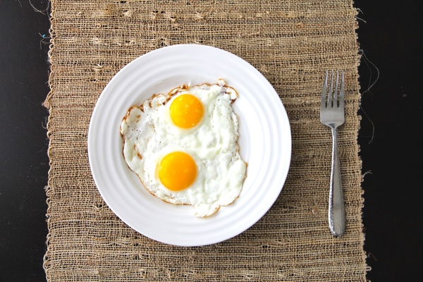 2 sunny side up eggs on plate with fork