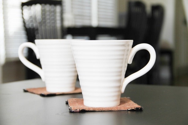 2 white coffee mugs on coasters