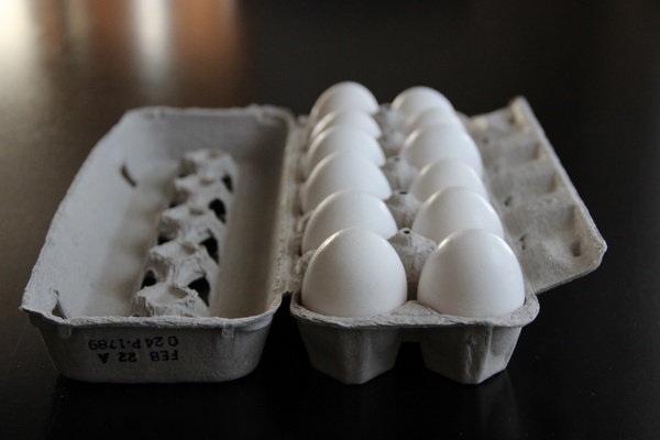 a dozen white eggs in a carton