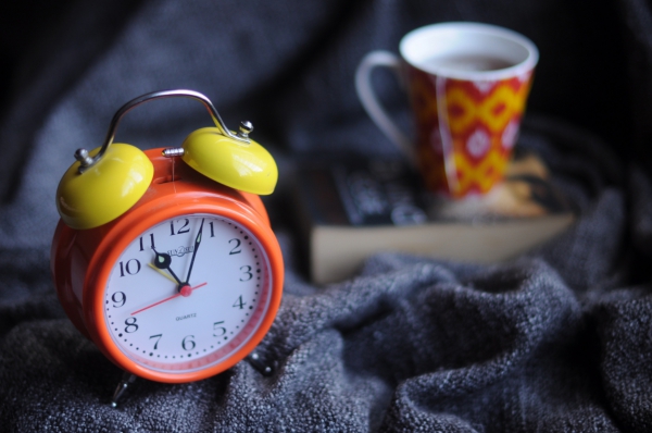 closeup of alarm clock near coffee cup 