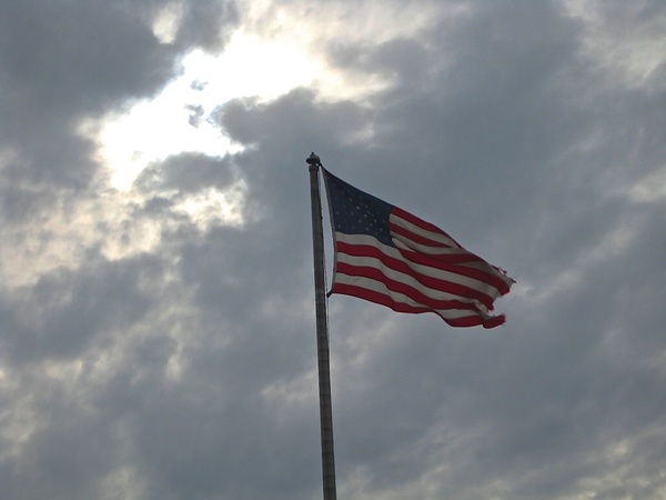 american flag waving on cloudy sky