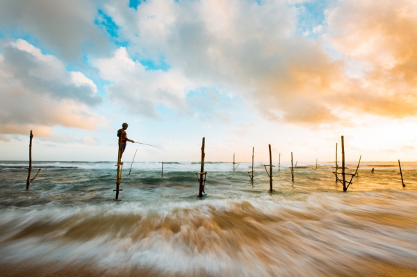 fisherman fishing on sea wooden piles