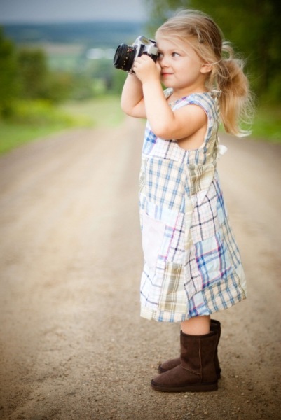 cute small blonde girl posing with camera