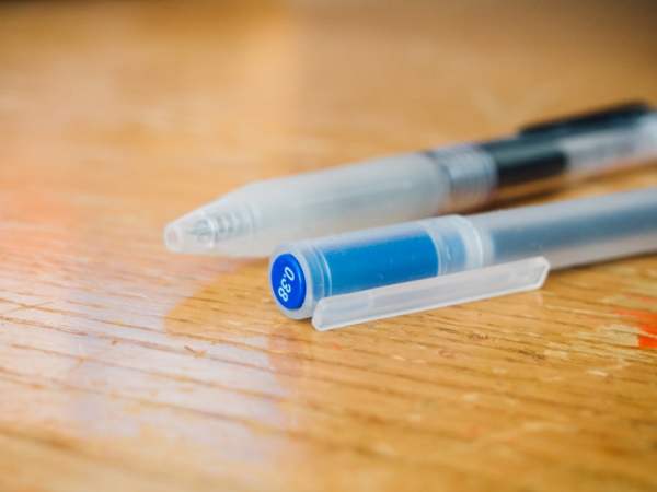 blue and black pens on desk 