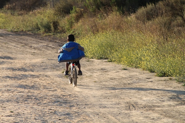 boy riding bike down dirt path