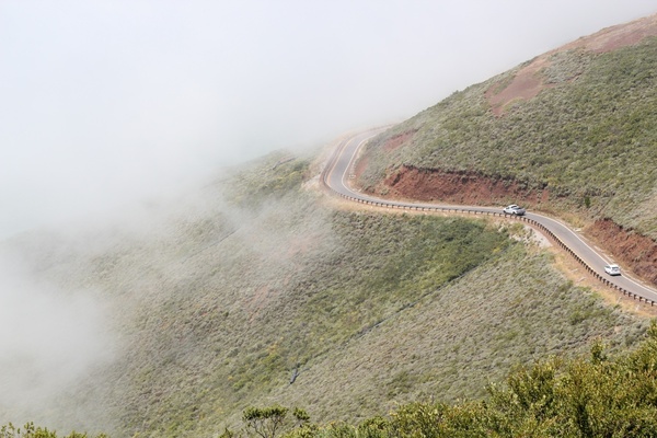 cars driving on winding mountain road in fog