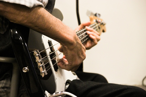 close up of man playing bass guitar 