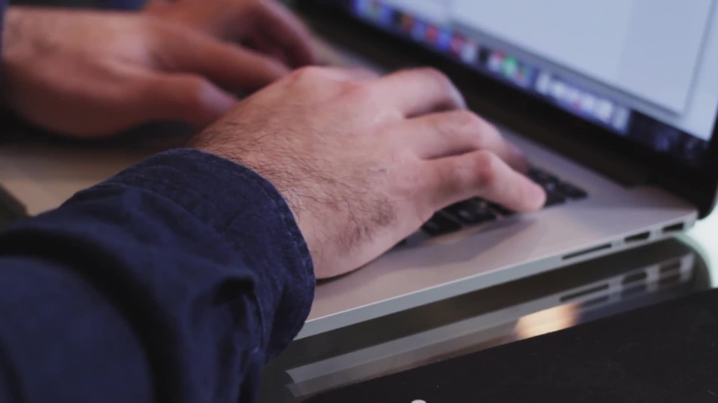 closeup of man typing on laptop keyboard