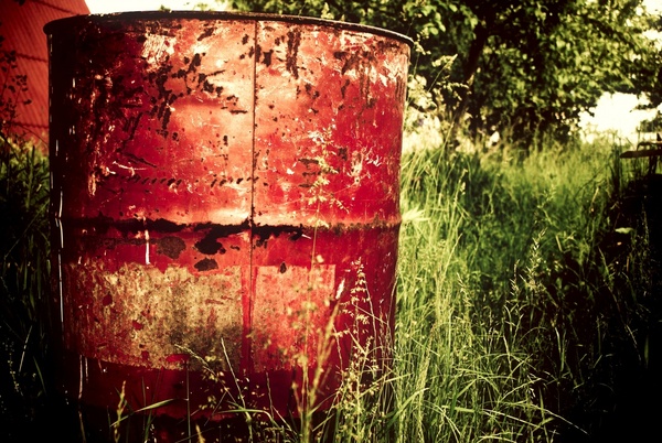 container drum field grass oil rust tree 