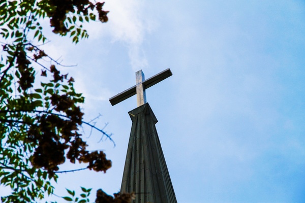 cross on church steeple on blue sky