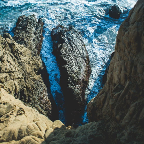 deep dark blue sea waves breaking on a rocks forming a sea