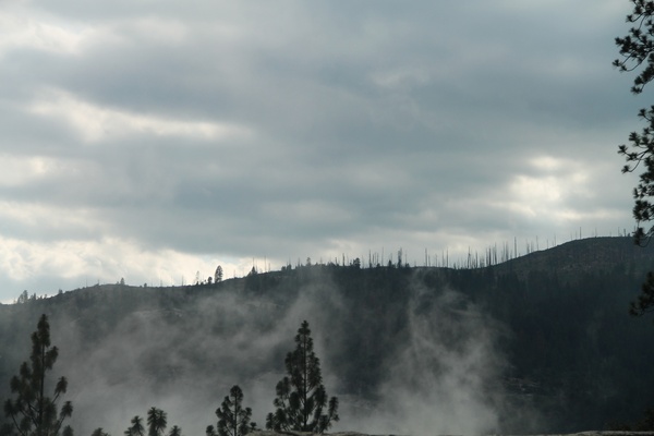 fog rising in front of barren mountain