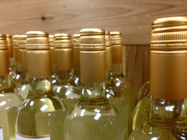 gold bottles of wine against wooden board