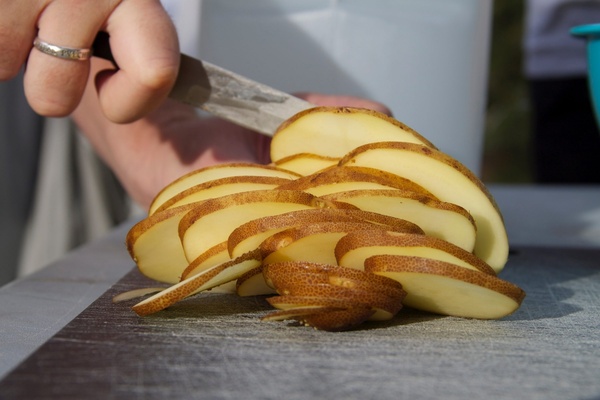 knife cutting potato slices 