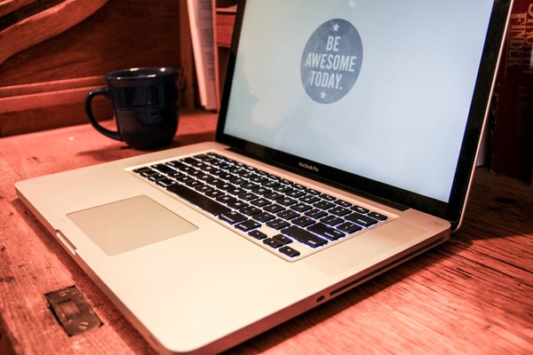 macbook laptop with 8220be awesome8221 screen with coffee mug