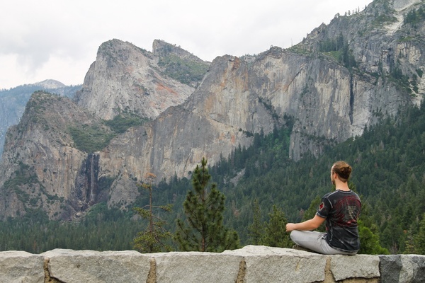 man meditating by mountains