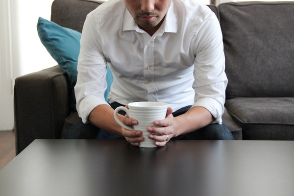 man on couch with coffee mug