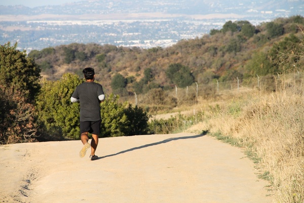 man running on dry dirt trail
