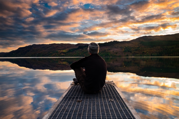 man sitting by lake