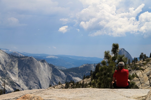 man sitting on rock looking at scenic view