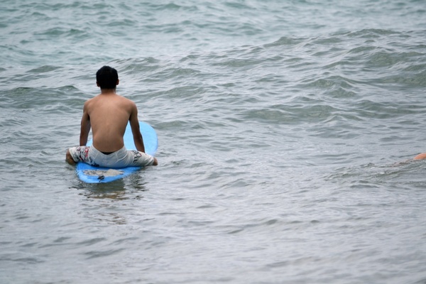man sitting on surfboard on ocean