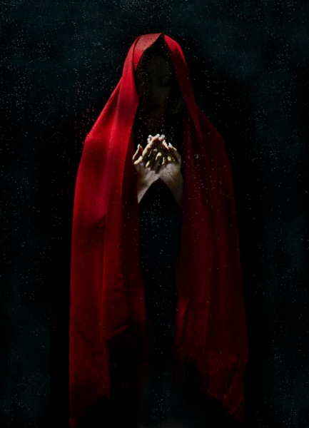 magical human in dark with red head covering