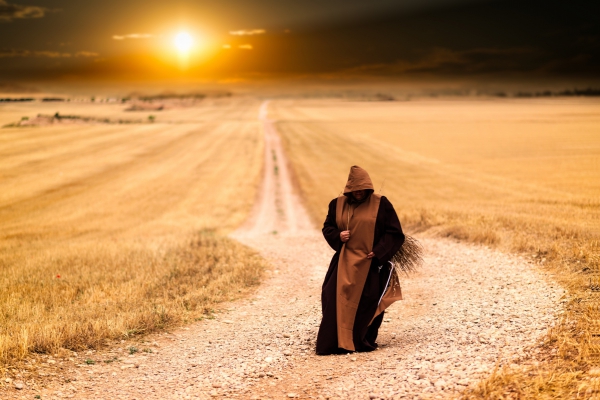 mysterious monk walking alone during sunset