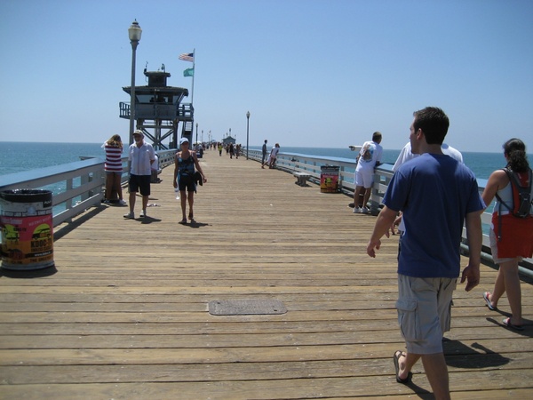 people walking along ocean pier