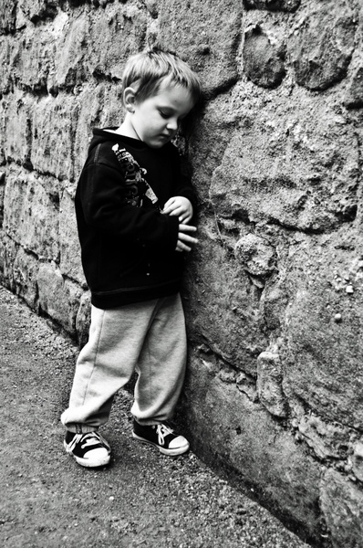 sad child at a stone wall