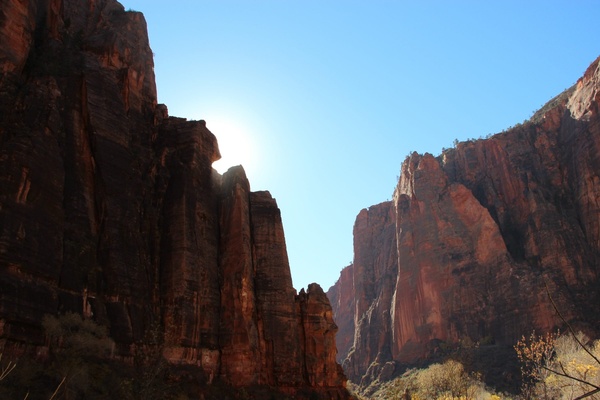 sun behind cliffs in canyon 
