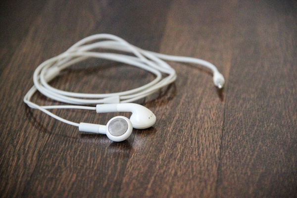 white earphones on wood desk