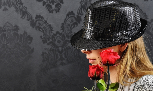 blonde woman posing with black hat and roses