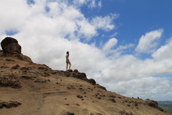 woman on rocky hill against clouds