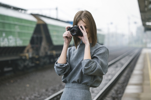 woman taking pictures at train station