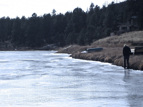 woman walking along edge of frozen lake