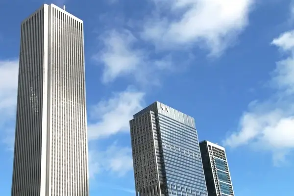3 tall buildings in sky with clouds