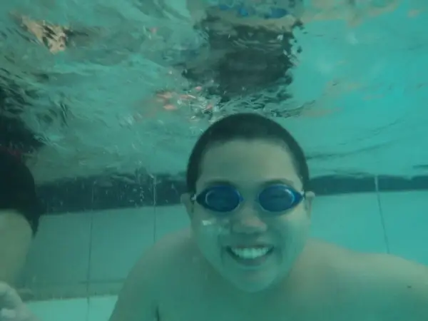 a boy smiling under water