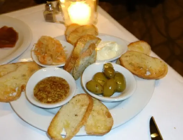bread with dipping sauce and olives