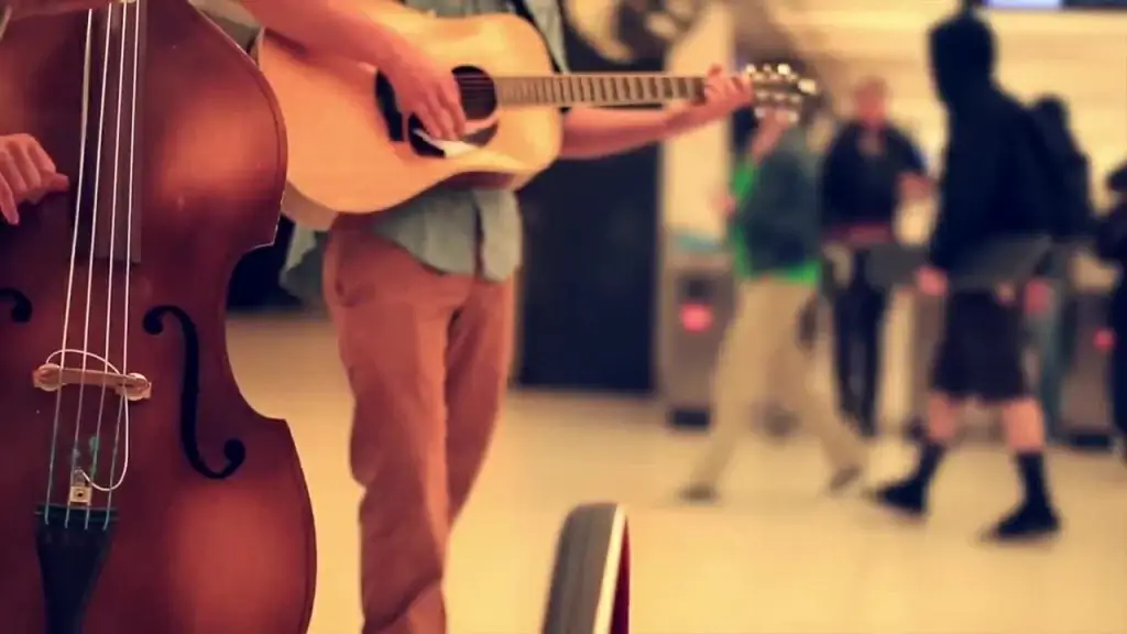 closeup of men performing acoustic guitar