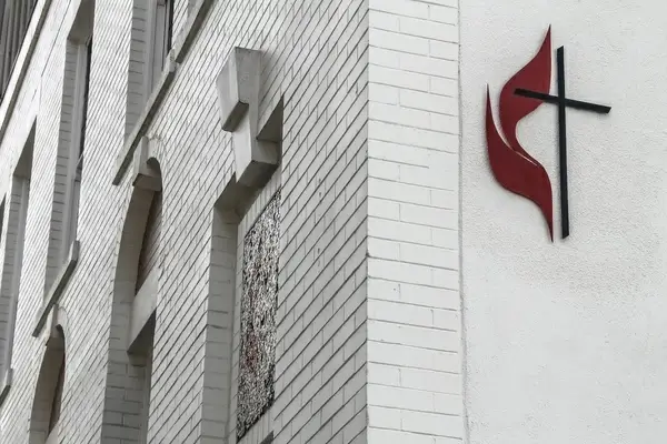 cross on white brick church building