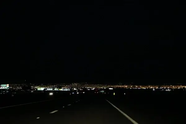 dark street leading to city lights at night