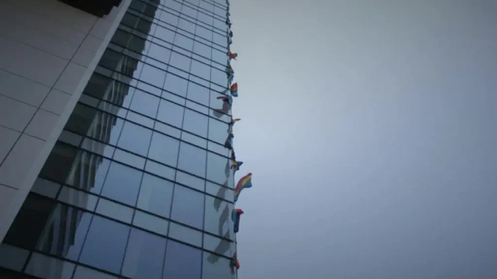 nation flags waving on glass skyscraper