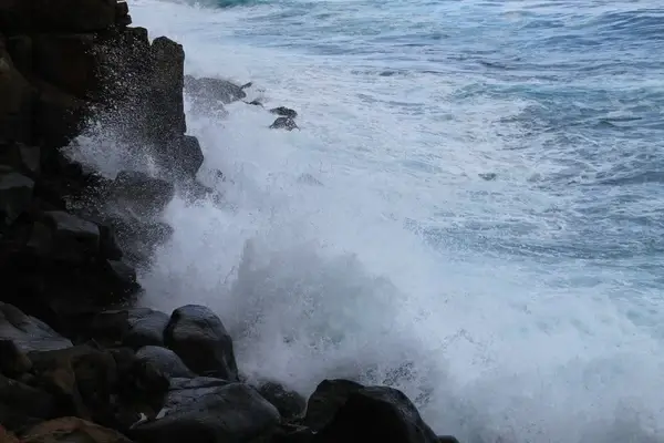 ocean waves crashing against rocks