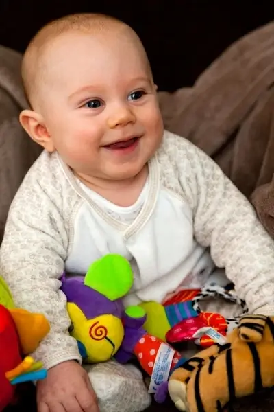 smiling baby with toys