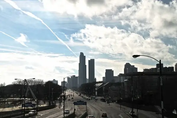 street going into downtown city with clouds in sky