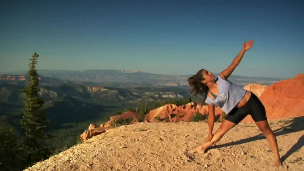woman performing yoga exercise on high mountain
