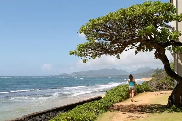 woman walking on path along beach
