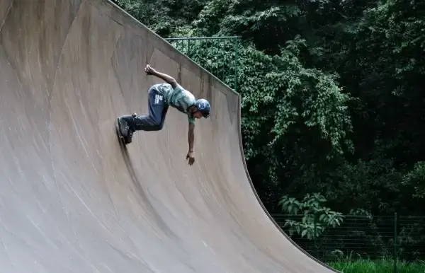 exciting man with roller skating on curved wall