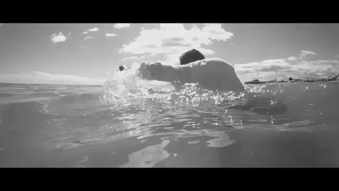 black white movie of man struggling in sea
