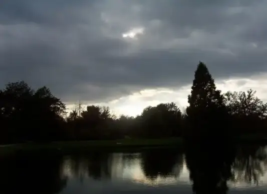 dark clouds over pond